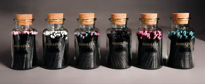 Apothekerflasche mit schwarzen Streichhölzern