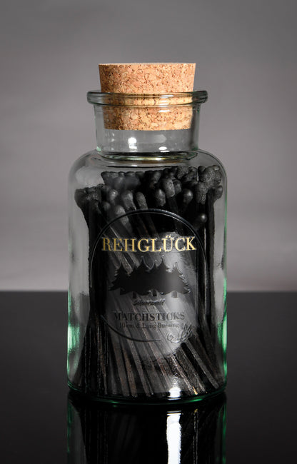 Apothekerflasche mit schwarzen Streichhölzern