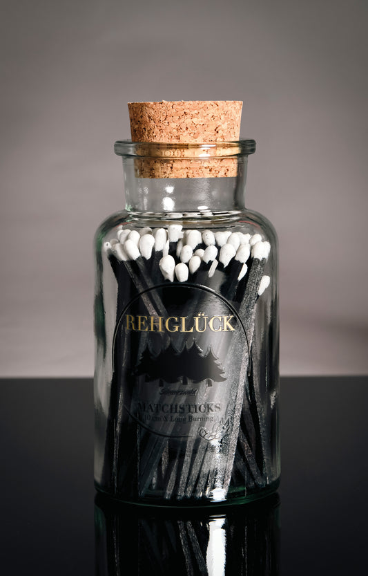 Apothekerflasche mit schwarzen Streichhölzern/Weiß