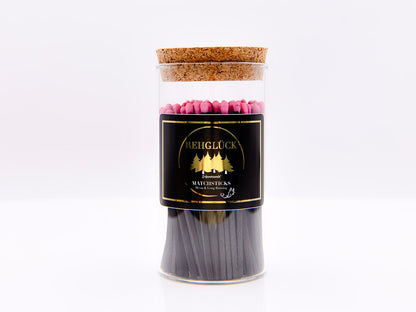 Zylinderglas schwarze Streichhölzer/pinker Kopf